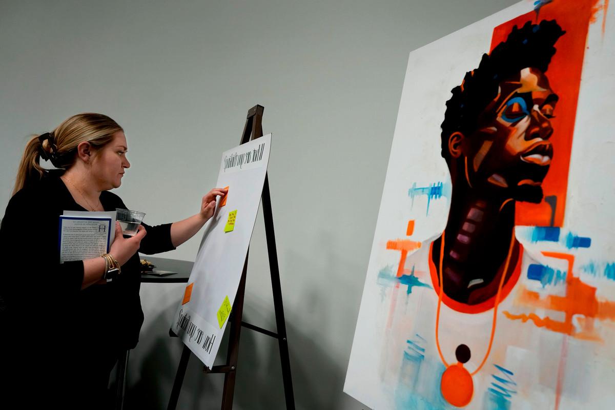 Erin Tucker from the Colorado Vocal Arts Ensemble (CVAE), posts a message on a “feeling board” after the performance of “Seven Last Words of the Unarmed” on March 9 in the Celeste Theatre in Cornerstone Arts Building. Photo by Jamie Cotten